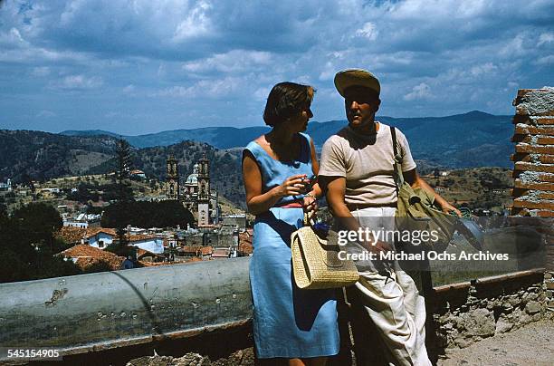 Couple talk overlook Santa Prisca Church in Taxco de Alarcon, Guerrero, Mexico.