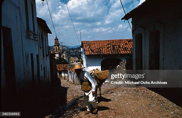 Man leads his donkey through a street in Taxco de Alarcon, Guerrero, Mexico.