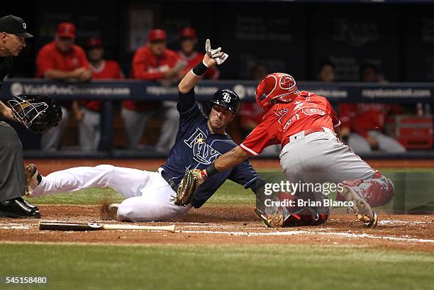 Catcher Carlos Perez of the Los Angeles Angels of Anaheim gets the out at home plate on Nick Franklin of the Tampa Bay Rays off of the fielder's...