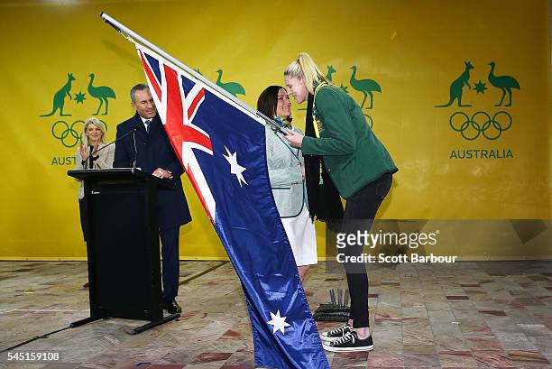 Anna Meares is presented with the Australian flag by Lauren Jackson, flagbearer for the 2012 London Olympic Games during the Australian Olympic Games...