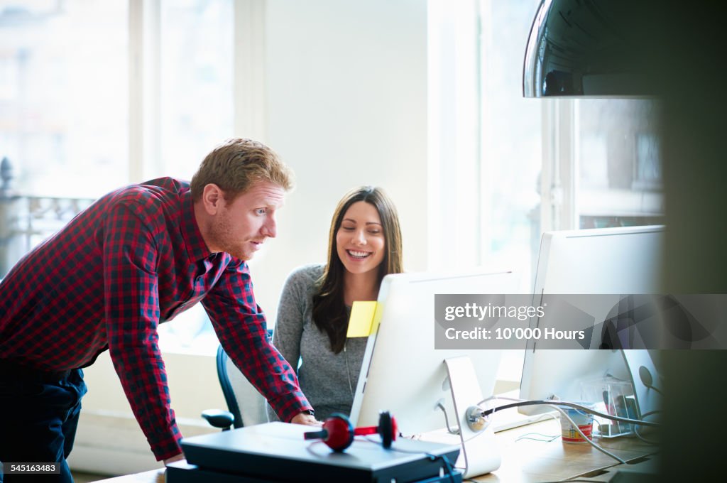 Two colleagues discussing a project on a computer
