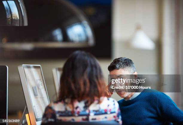 two business colleagues discussing a project - candid office stock-fotos und bilder