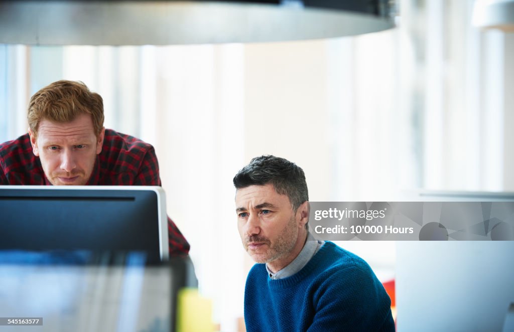 Two colleagues contemplating a project on computer