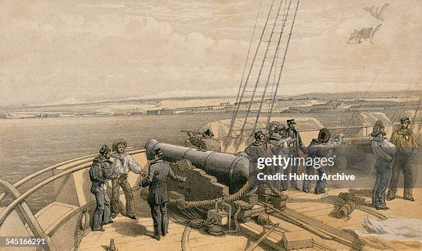 View of Sevastopol from the gun deck of HMS Sidon, a first-class paddle frigate as the crew operate a 68-pounder 88 cwt smoothbore muzzle-loading gun...