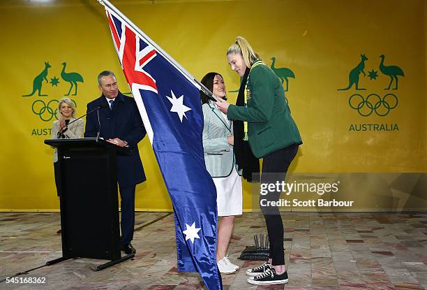 Anna Meares is presented with the Australian flag by Lauren Jackson, flagbearer for the 2012 London Olympic Games during the Australian Olympic Games...