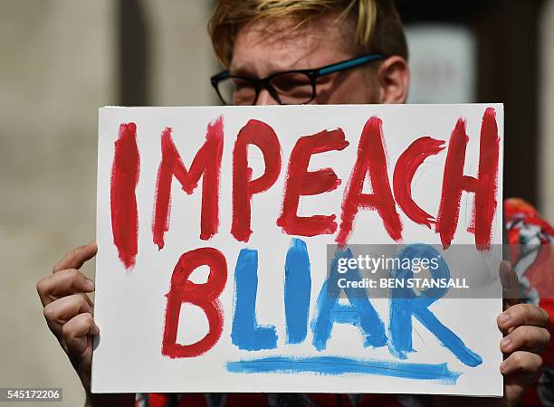 Demonstrator holds a placard as they protest outside QEII Centre in London on July 6 as they wait to hear the outcome of the Iraq Inquiry. The...