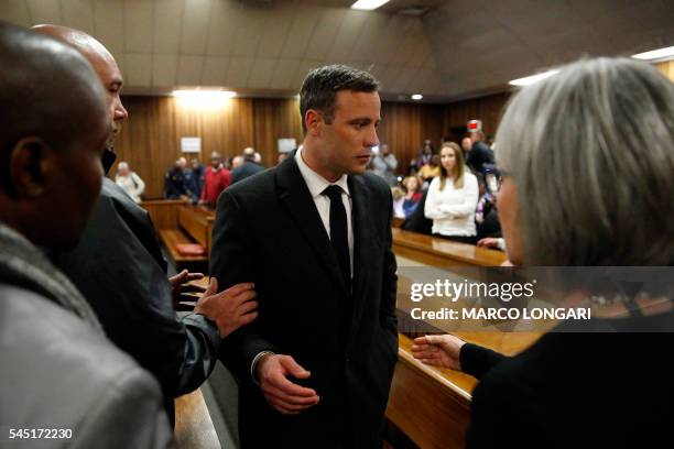 South African Paralympian athlete Oscar Pistorius speaks with relatives as he leaves the High Court in Pretoria, on July 6, 2016 after being...