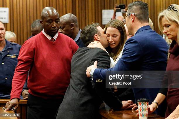 Olympic athlete Oscar Pistorius embraces his sister Aimee Pistorius , next to his brother Carl Pistorius as he leaves the High Court after sentencing...