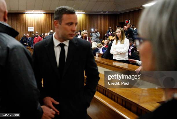 Olympic athlete Oscar Pistorius speaks with relatives as his sister Aimee Pistorius looks over at him after sentencing at the High Court on July 6,...