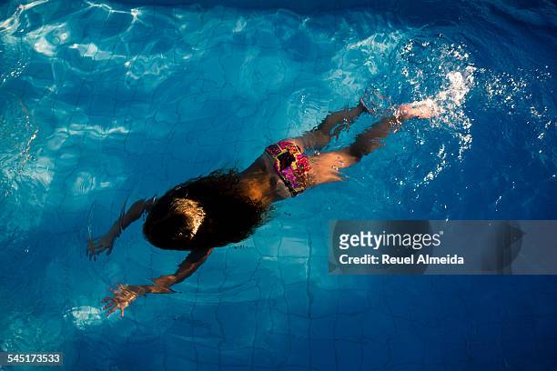 child swimming in a blue pool - gravata stock-fotos und bilder