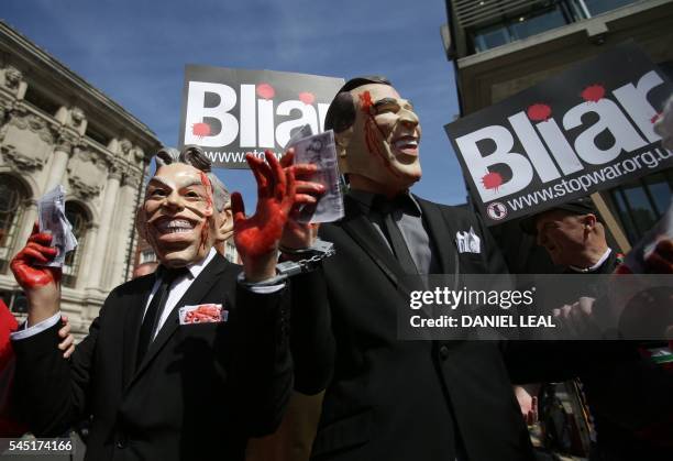 Demonstrators wearing masks depicting former British Prime Minister Tony Blair and former US President George W. Bush protest outside QEII Centre in...