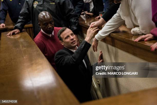 South African Paralympian athlete Oscar Pistorius reacts as he leaves the High Court in Pretoria, on July 6, 2016 after being sentenced to six years...