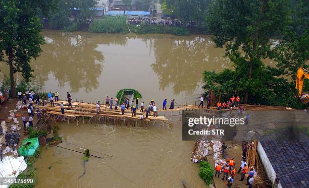 Chinese soldiers and workers try to repair a collapsed dam along the Xiangyang River in Xinji Village in Yangzhou, in east China's Jiangsu province...