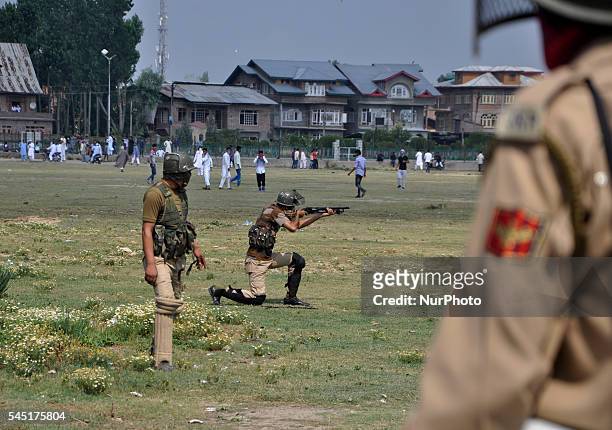 An Indian policeman Aims a pellet gun towards kashmiri Muslim protesters chanting Pro-freedom slogns during clashes after prayers marking the...