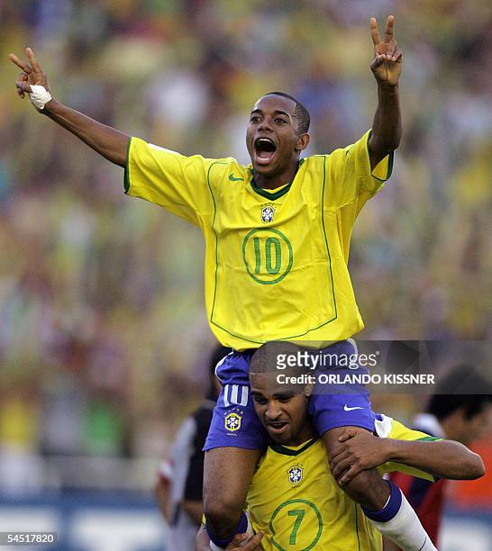 Brazilian striker Robinho is carried by forward Adriano celebrating Adriano's third goal against Chile, during their South American qualifier match...