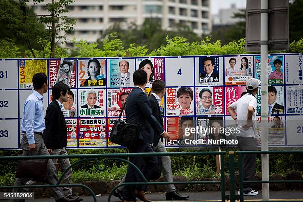 Man look at campaign posters with pictures of candidates for the 2016 Upper House election in Tokyo, Japan, on Tuesday, July 5, 2016. Japanese voters...