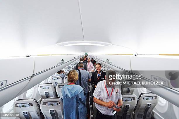 Cabin crew member welcomes guests inside Swiss International Air Lines' new Bombardier CS 100 passenger jetliner during its presentation at Zurich...