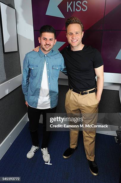 Olly Murs poses for pictures with DJ Alex Mansuroglu during a visit to Kiss FM on July 6, 2016 in London, England.