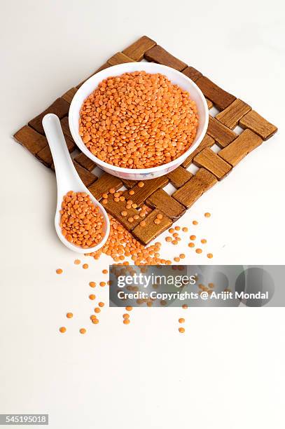 masoor dal in a bowl isolated on white background with spoon and table mat - dal stock-fotos und bilder