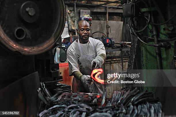 Rudyt Martinez throws a glowing hot horseshoe on the pile at St. Pierre Manufacturing Corporation in Worcester, Mass., on June 28, 2016. St. Pierre...