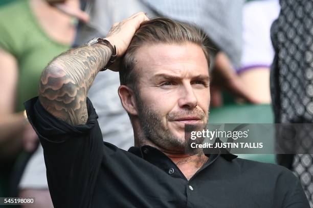 Former England footballer David Beckham watches Switzerland's Roger Federer's victory on centre court after he beat Croatia's Marin Cilic in their...