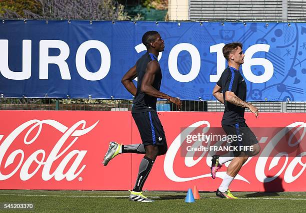 France's midfielder Paul Pogba runs behind France's forward Antoine Griezmann during a training session in the southern French city of Marseille on...
