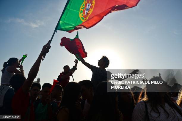 Portugal football team's supporters wave flags and scarfs as they gather on Terreiro do Paco square in Lisbon on July 6 moments before the start of...
