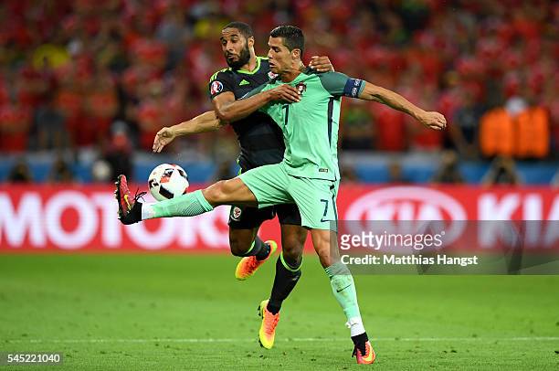 Cristiano Ronaldo of Portugal controls the ball under pressure of Ashley Williams of Wales during the UEFA EURO 2016 semi final match between...