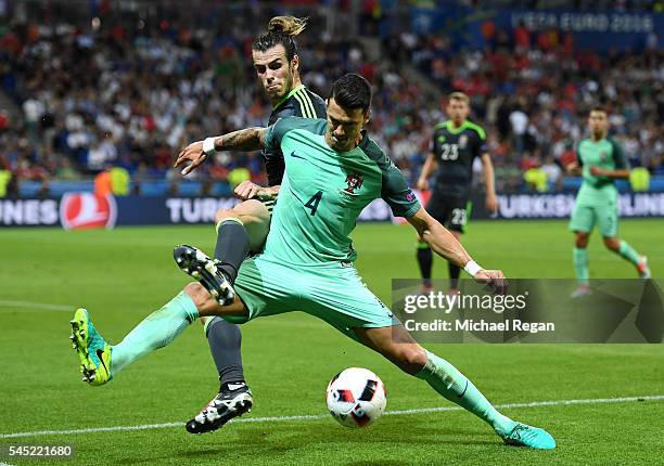 Gareth Bale of Wales battles for the ball with Jose Fonte of Portugal during the UEFA EURO 2016 semi final match between Portugal and Wales at Stade...