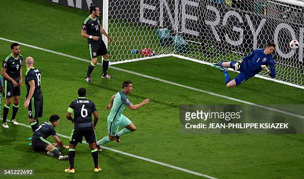 Portugal's forward Cristiano Ronaldo celebrates scoring the opening goal past Wales' goalkeeper Wayne Hennessey during the Euro 2016 semi-final...