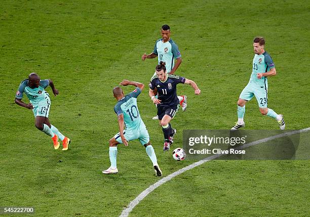 Gareth Bale of Wales controls the ball under pressure of Portugal defense during the UEFA EURO 2016 semi final match between Portugal and Wales at...