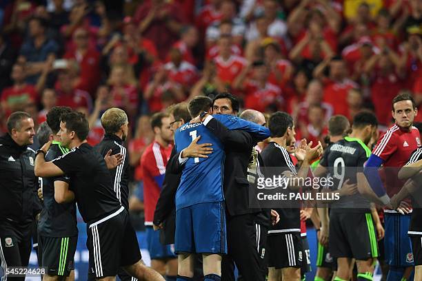 Wales' coach Chris Coleman embraces Wales' goalkeeper Wayne Hennessey at the end of the Euro 2016 semi-final football match between Portugal and...