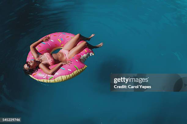 brunette teen in donuts inflatable ring. - tube girl stock-fotos und bilder