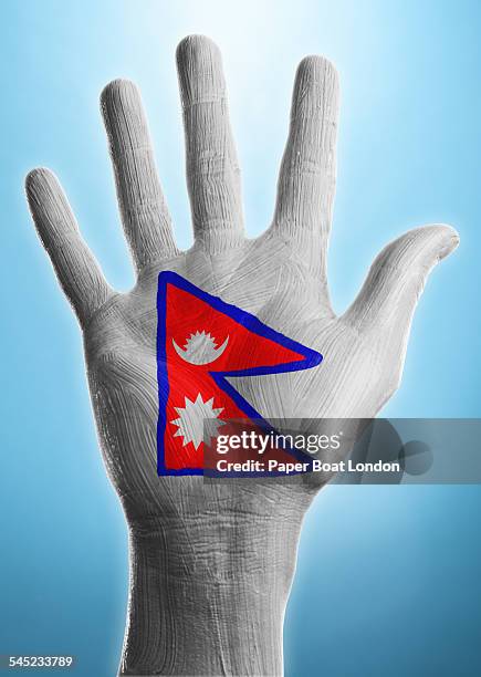 open hand with flag of nepal painted on it - nepali flag stockfoto's en -beelden