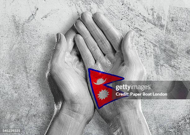 flag of nepal painted on two hands together - nepal flag stock pictures, royalty-free photos & images