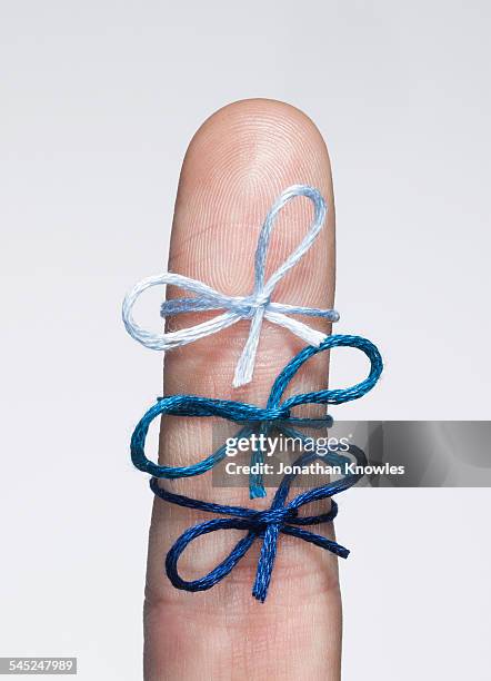 three string bows tied on a finger - lazo cuerda fotografías e imágenes de stock