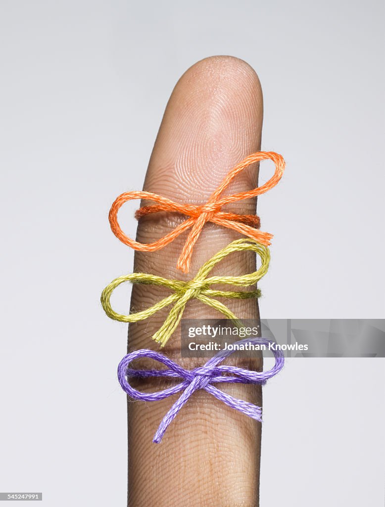 Three string bows tied on a finger