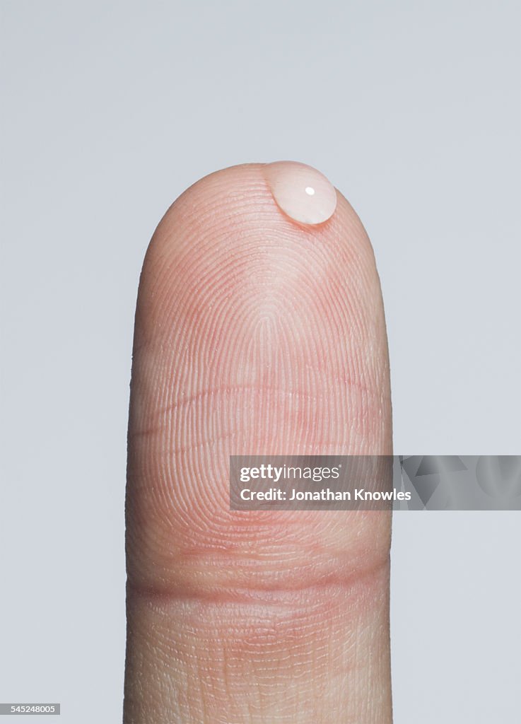 Finger with a bead of water