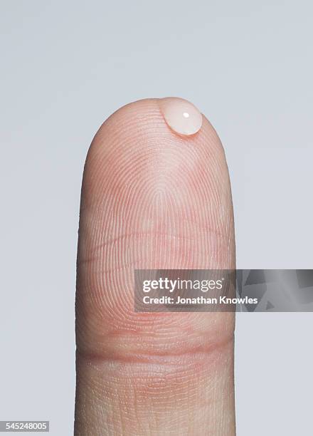 finger with a bead of water - dito umano foto e immagini stock