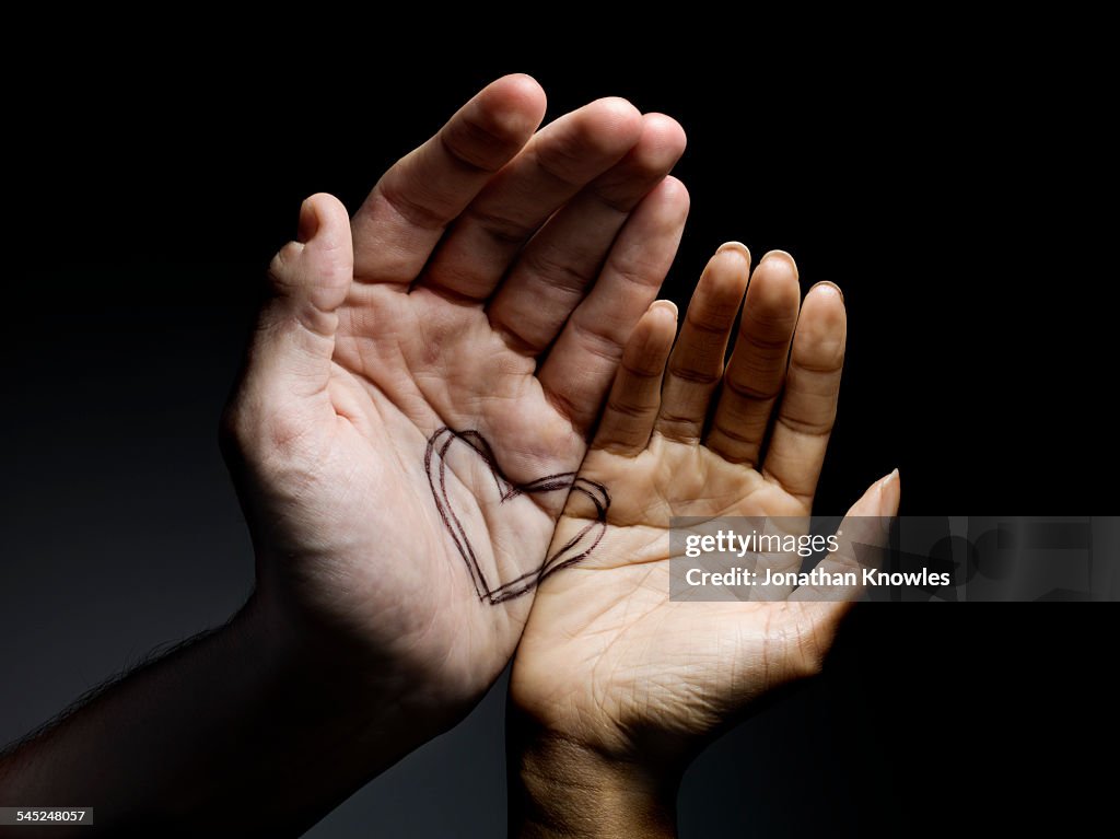 Two hands connected with heart drawing