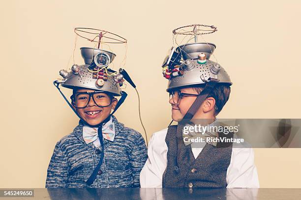 zwei jungen gekleidet als nerds lächeln mit gedanken lesen helme - vintage funny black and white stock-fotos und bilder