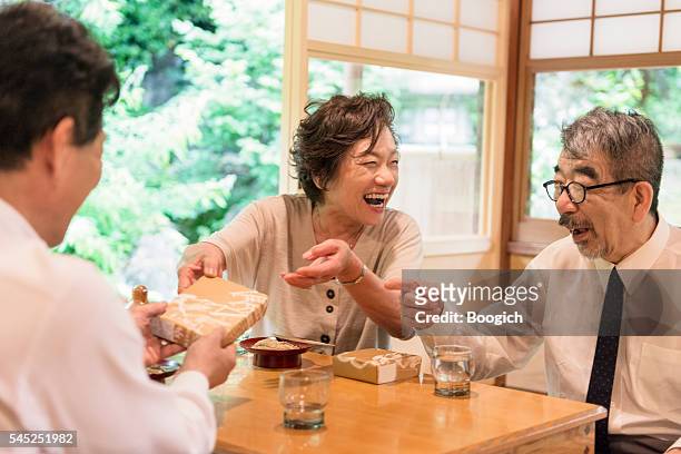 des amis japonais seniors donnent un cadeau au restaurant kyoto japon - gift japan photos et images de collection