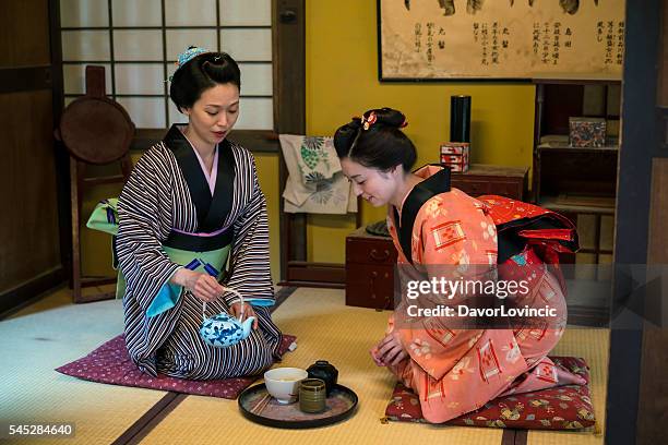 women having traditional japanese tea in kyoto japan - tea ceremony stock pictures, royalty-free photos & images