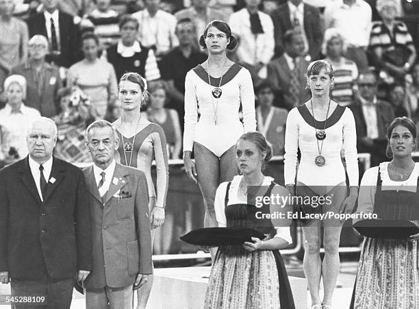 View of the podium and medal winners for the Women's artistic individual all-around gymnastics competition; silver medal winner Karin Janz of East...