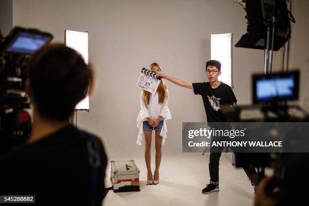 In this picture taken on June 7 an actress prepares to perform as a crew member signals the start of a take with a clapper-board on the set of recent...