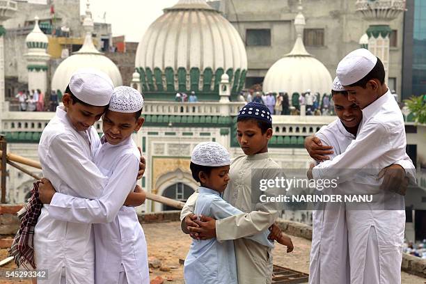 Indian Muslims embrace after offering Eid prayers on the occasion of the Eid al-Fitr festival which marks the end of the holy month of Ramadan at the...