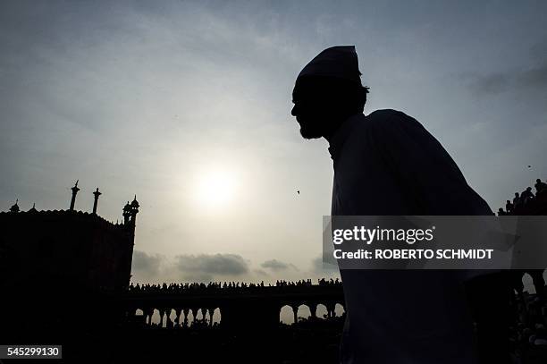 Muslim man walks into the courtyard of the Jama Masjid as he and others wait for the start of morning prayers on the occasion of the Eid al-Fitr...