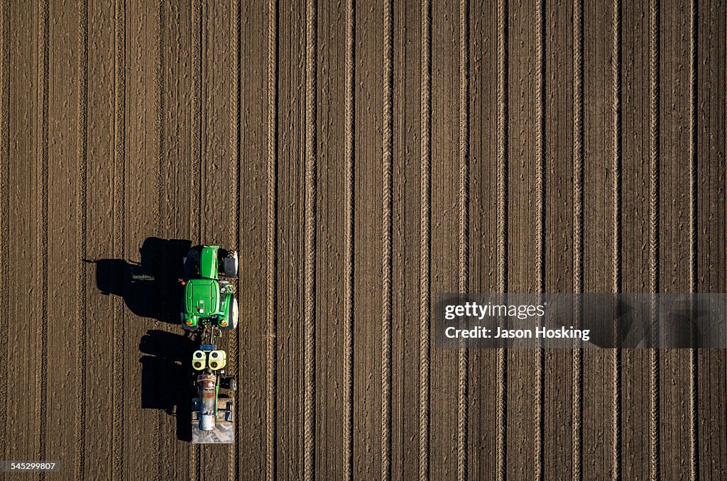 Aerial view of tractor driving over bare dirt