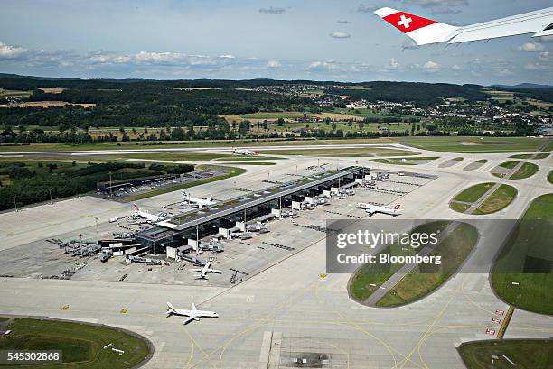 Swiss national flag sits on the wingtip of a Bombardier Inc. CS 100 C Series jet, operated by Swiss International Air Lines AG, as Zurich Airport,...