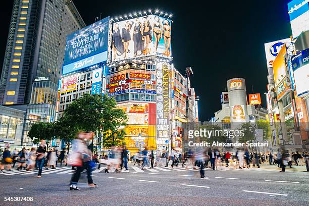 shibuya crossing with illuminated neon signs at night, tokyo, japan - distrito de shibuya fotografías e imágenes de stock